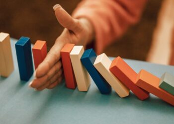 Crisi d'impresa: una mano ferma la caduta delle tessere del domino