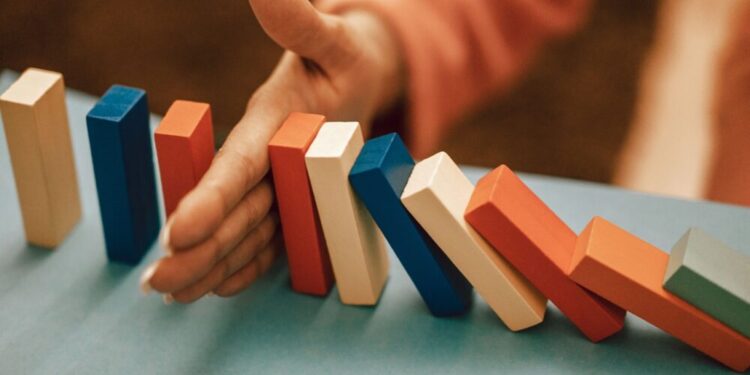 Crisi d'impresa: una mano ferma la caduta delle tessere del domino