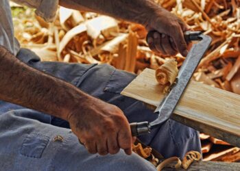 Riforma dell'artigianato: falegname al lavoro con la pialla