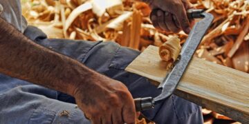 Riforma dell'artigianato: falegname al lavoro con la pialla